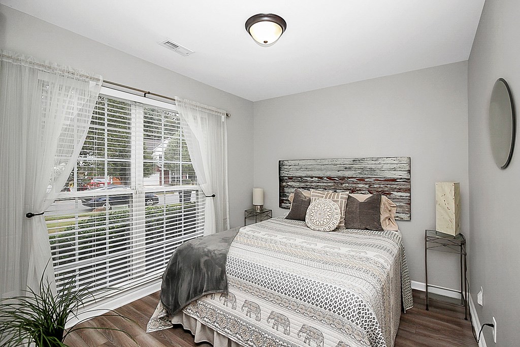 a bedroom with a bed and a large window