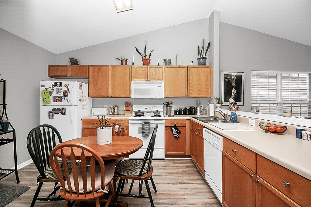 a kitchen with wooden cabinets and a table and chairs