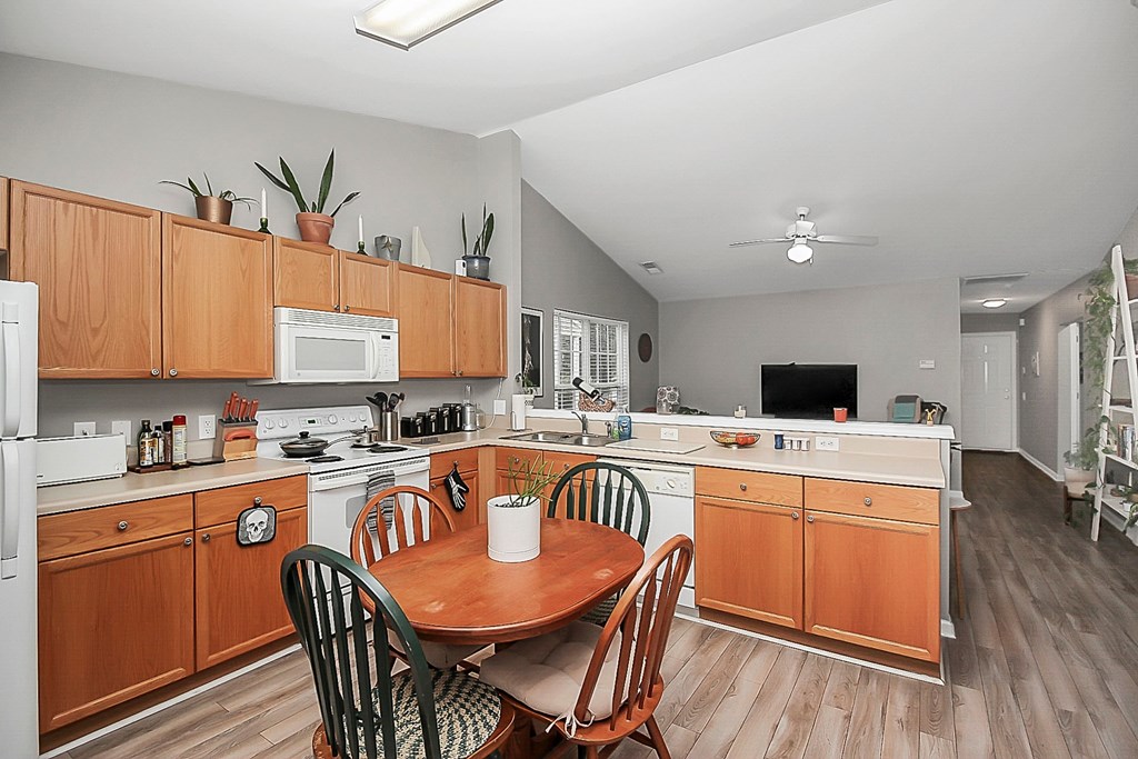 a kitchen with wooden cabinets and a table and chairs