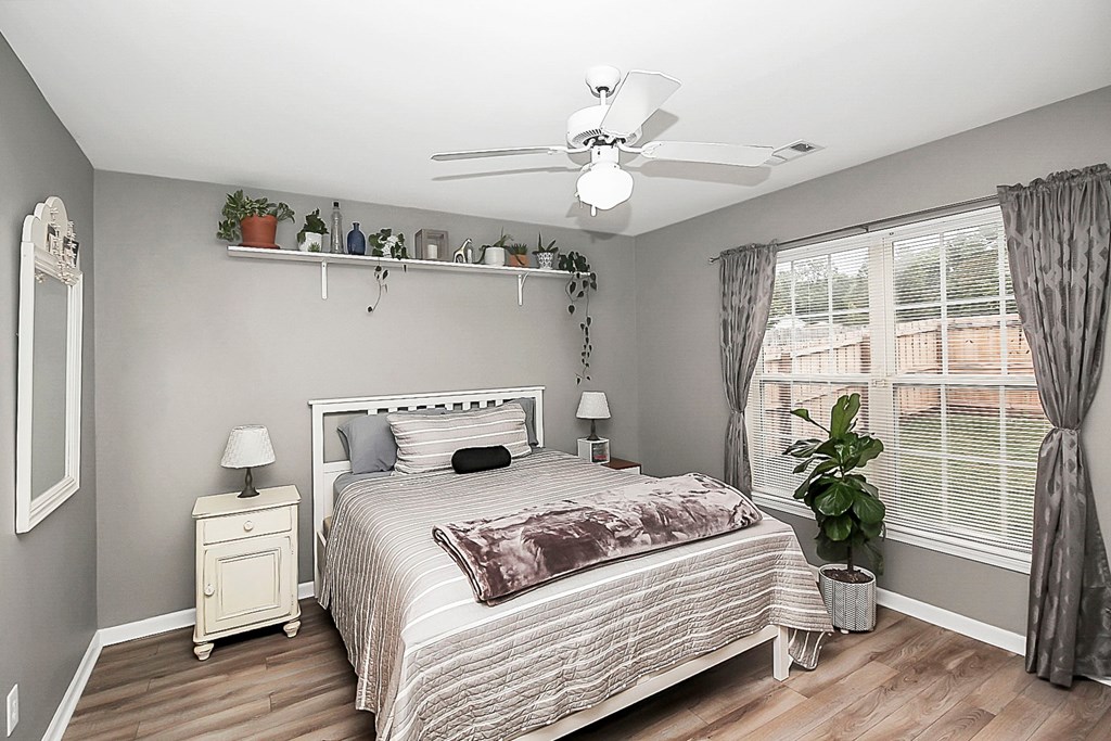 a bedroom with a bed and a ceiling fan