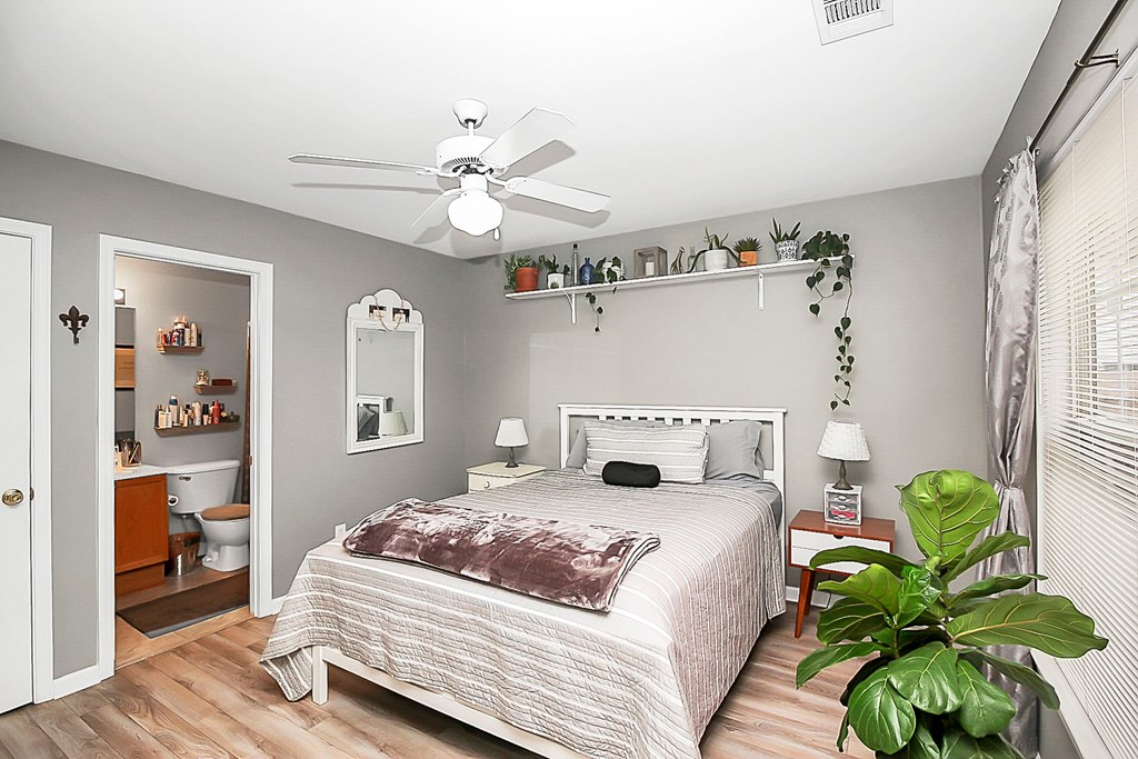 a bedroom with a bed and a ceiling fan
