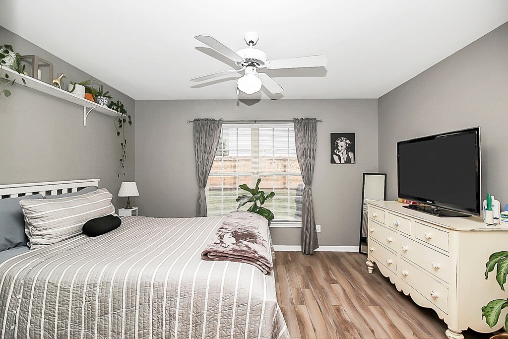 a bedroom with a bed and a ceiling fan
