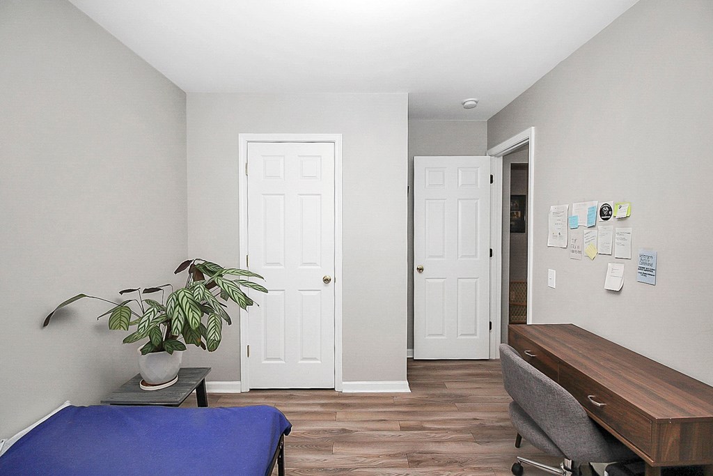 a small room with a couch and a desk and two doors