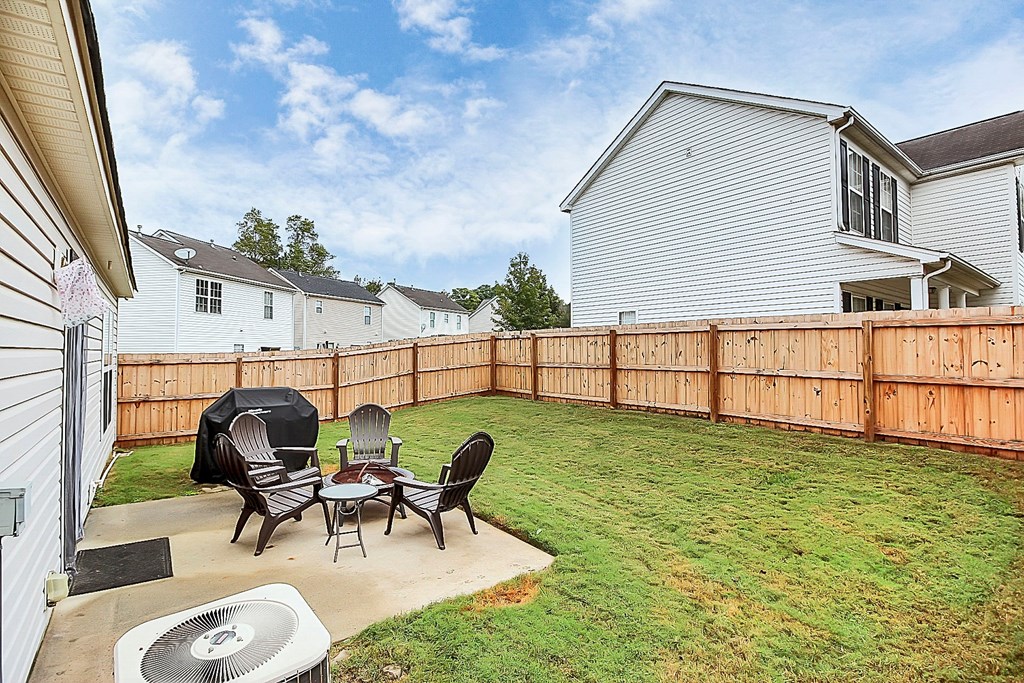 a backyard with a wooden fence and a table and chairs