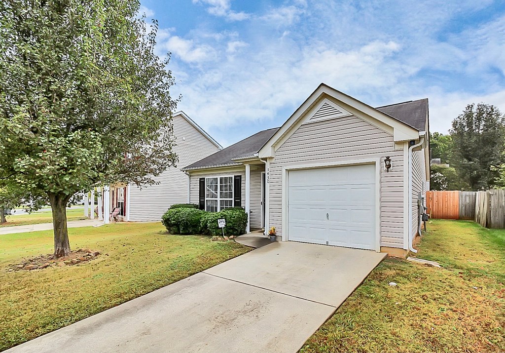 a white house with a white garage door and a driveway