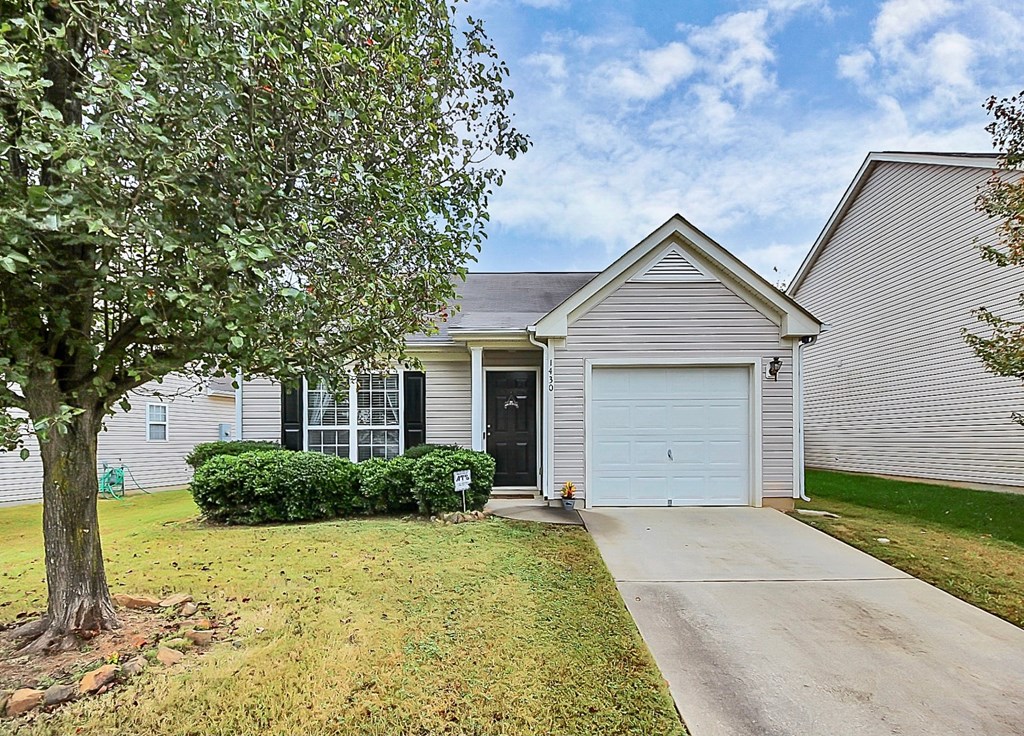 the front of a white house with a white garage door