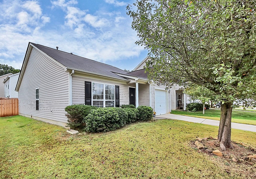 a white house with a yard and a tree