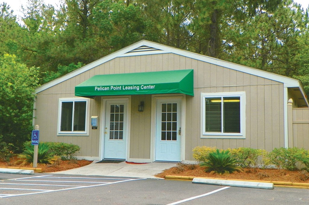 a building with a green awning and a parking lot