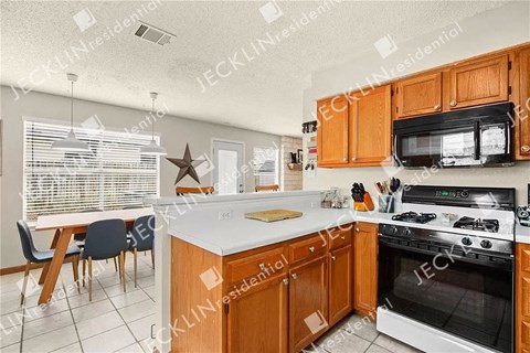 A kitchen with wooden cabinets and a white countertop.