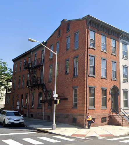 a woman standing in front of a brick building