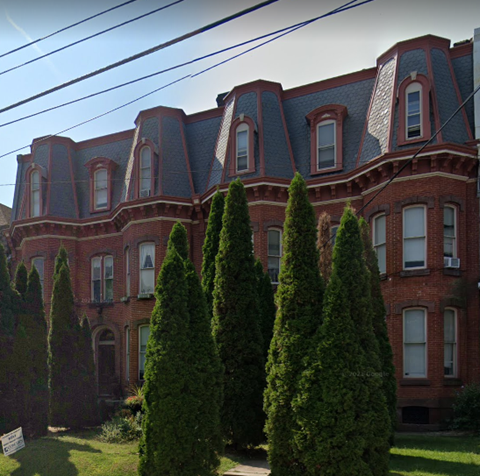 a large brick building with trees in front of it