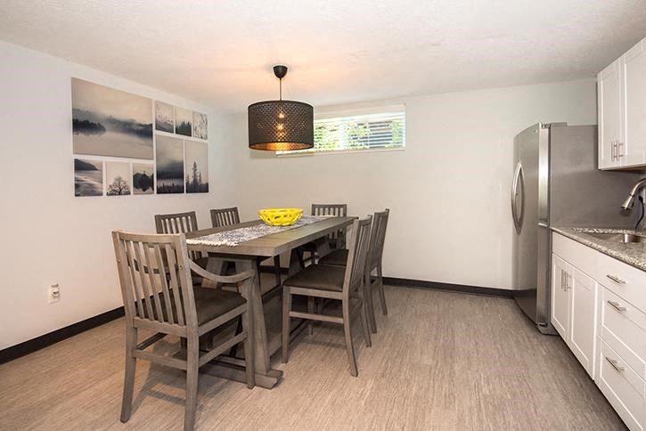a kitchen with a table and chairs and a refrigerator