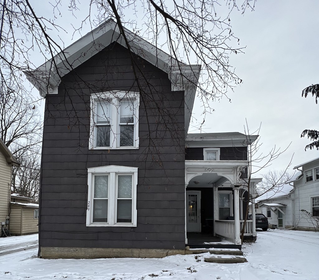 a house with black siding and white windows in the snow