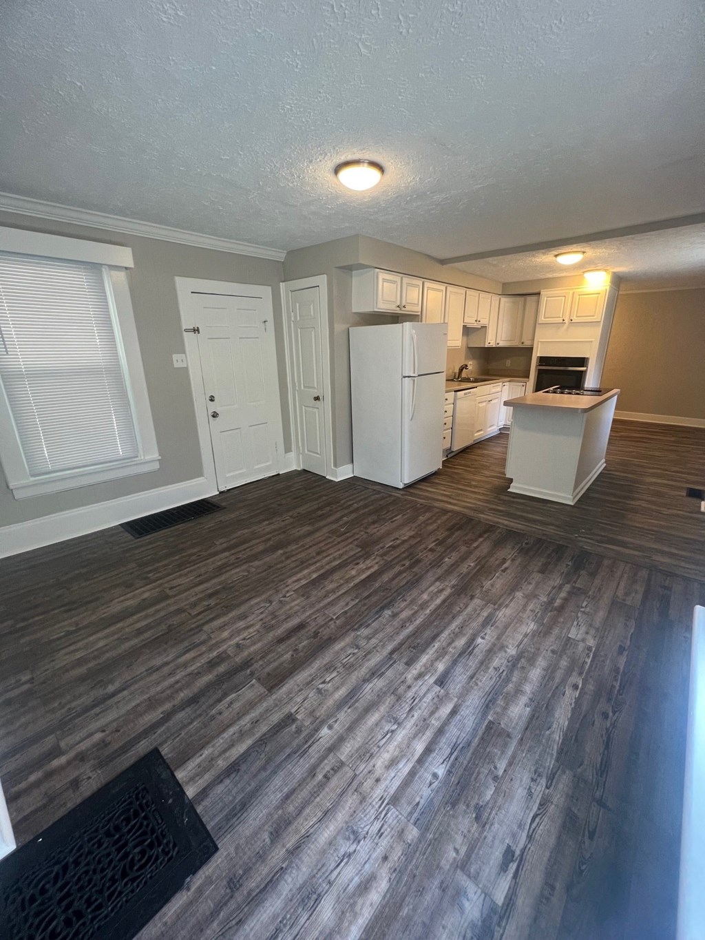 an open kitchen and living room with wood floors