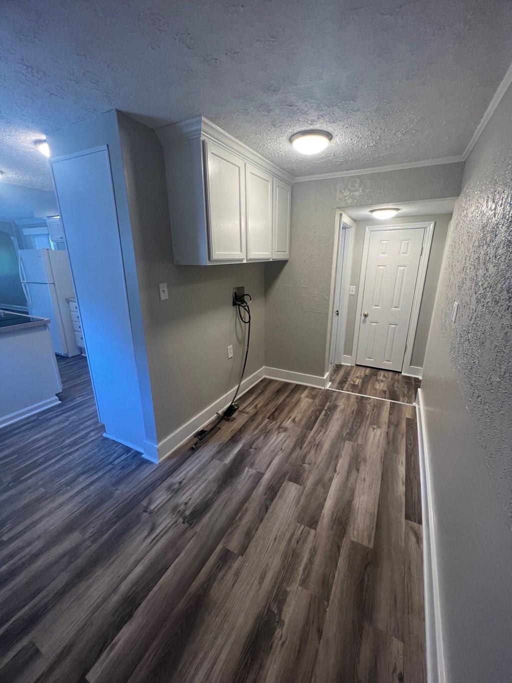 a renovated living room with wood floors and white cabinets