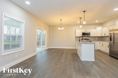 A spacious kitchen and living room with a dining table and chairs.