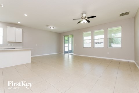A spacious room with a ceiling fan and tiled flooring.