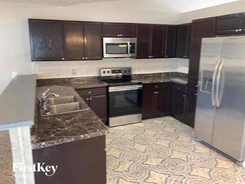 a kitchen with dark wood cabinets and stainless steel appliances