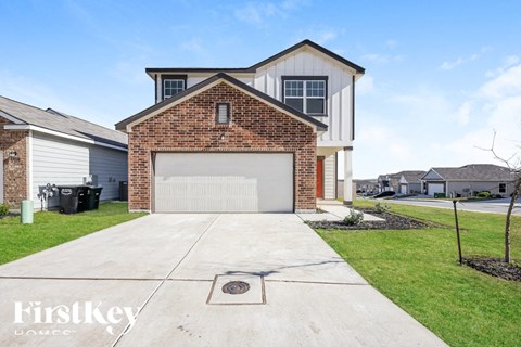 A brick house with a garage door is for sale.