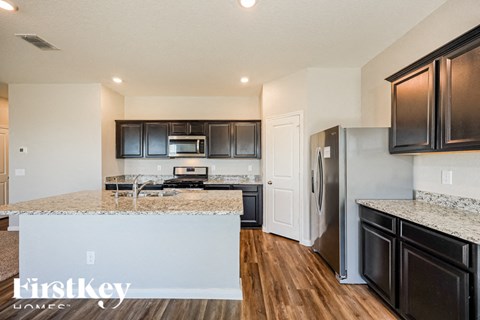 A kitchen with dark brown cabinets and a white fridge.