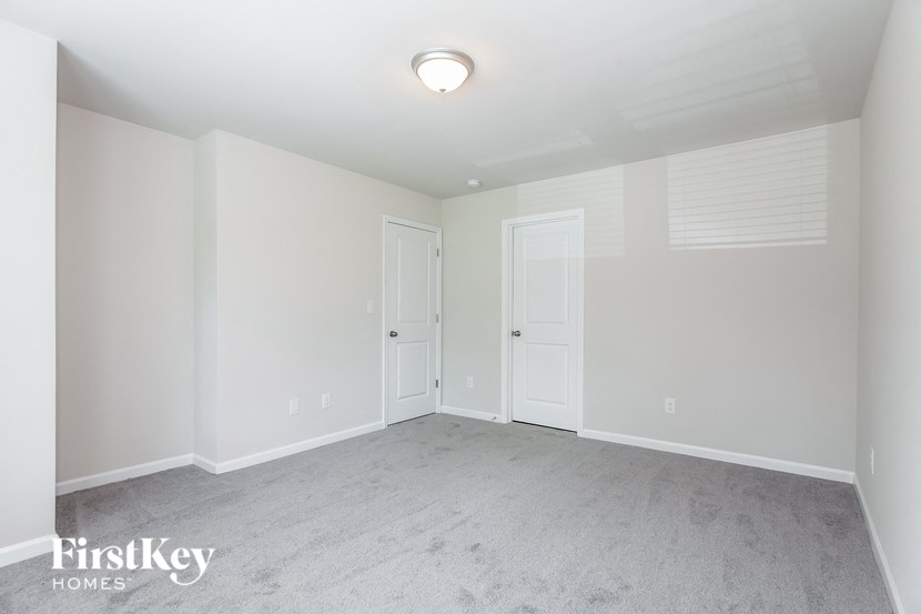 a bedroom with a carpeted floor and two doors