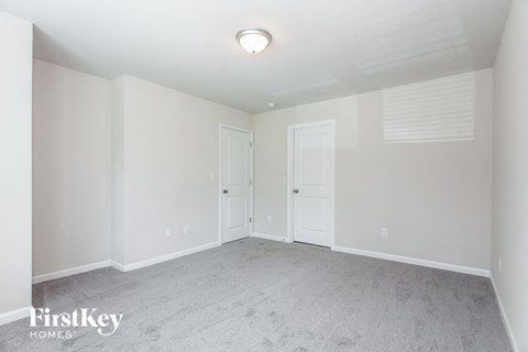 a bedroom with a carpeted floor and two doors