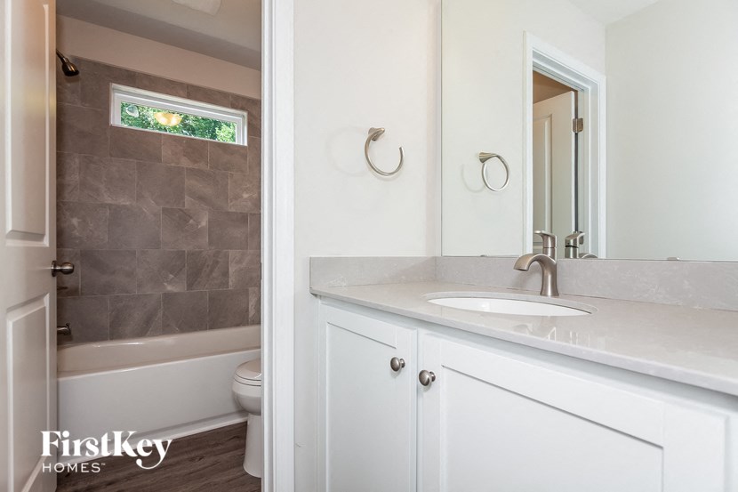 a bathroom with a sink and a tub and a mirror