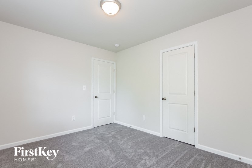 a bedroom with two doors and a carpeted floor