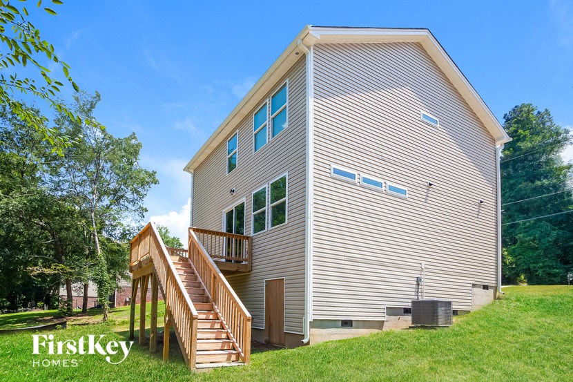 a tall house with a wooden deck on the side of it