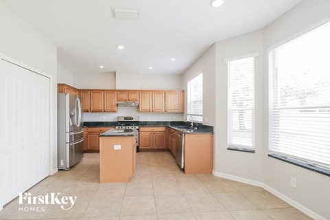 A kitchen with wooden cabinets and a stainless steel refrigerator.