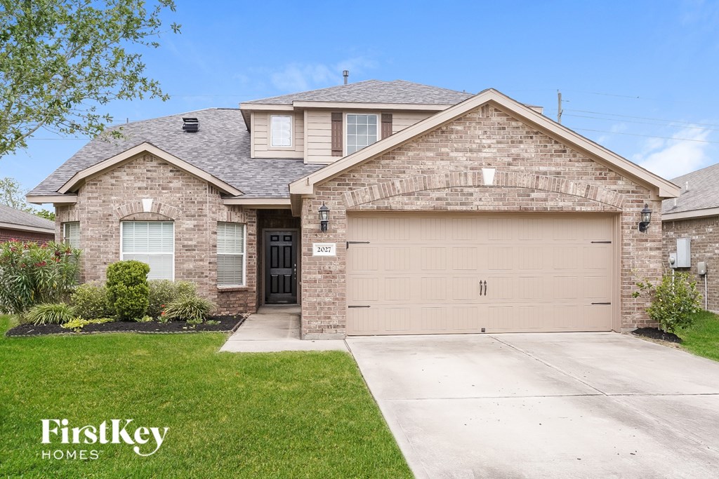 A house with a garage and a driveway in front of it.