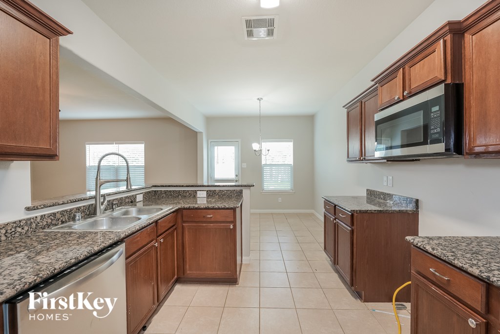 A kitchen with wooden cabinets and granite countertops.