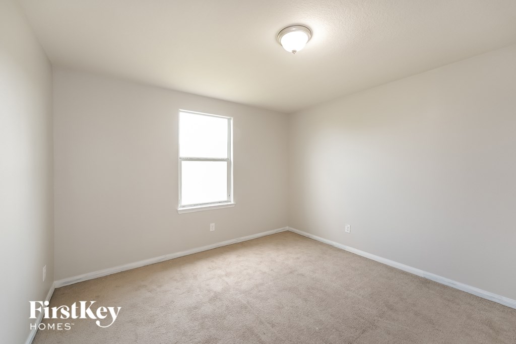 A room with a window and carpeted floor.