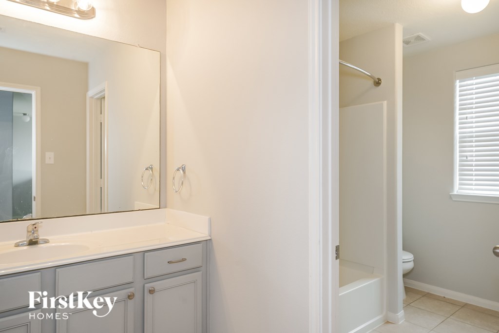 A bathroom with a white sink and a mirror.