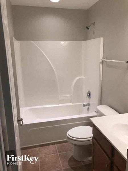 a white bathroom with a toilet and a tub