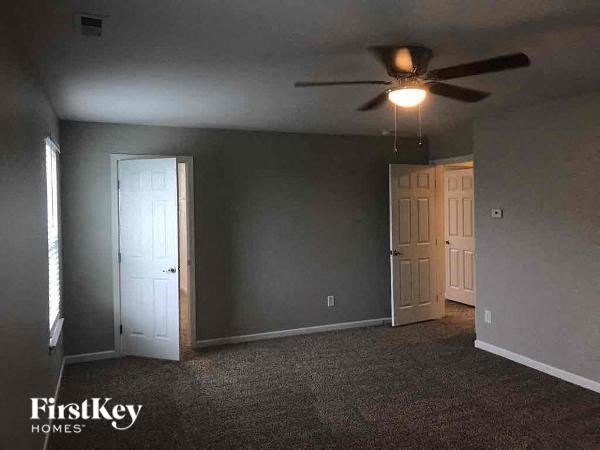 a empty room with a ceiling fan and a door