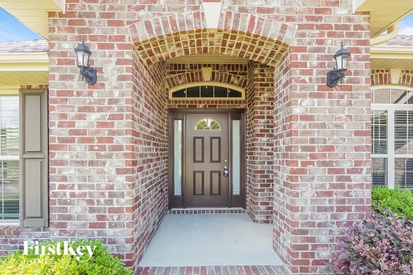 the front door of a brick house with a porch
