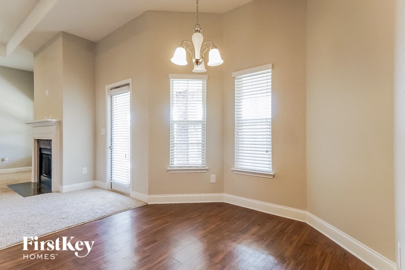 an empty living room with a fireplace and windows