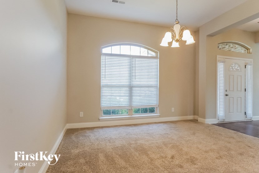 an empty living room with a large window and a white door