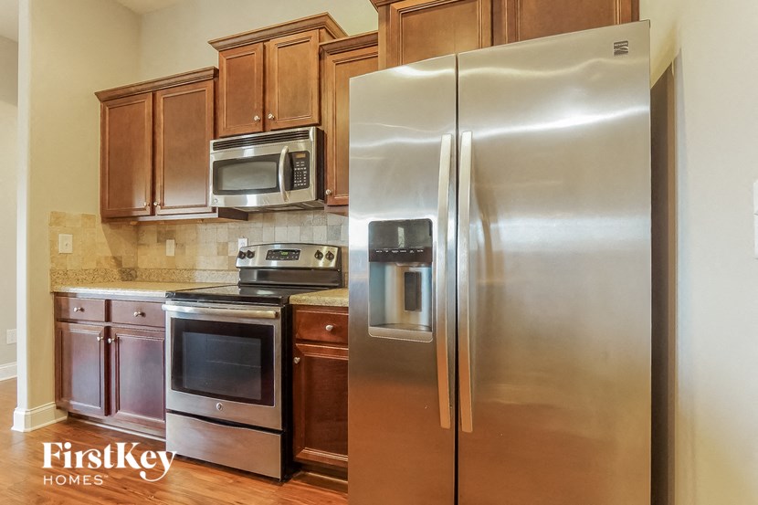 a stainless steel refrigerator in a kitchen with wooden cabinets