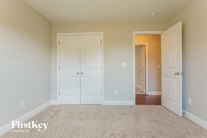 a bedroom with two closets and a carpeted floor