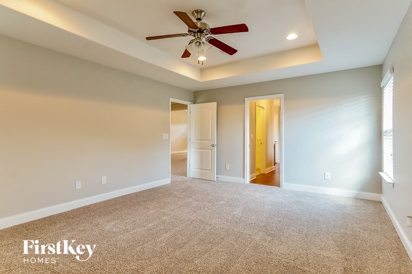 an empty living room with a ceiling fan