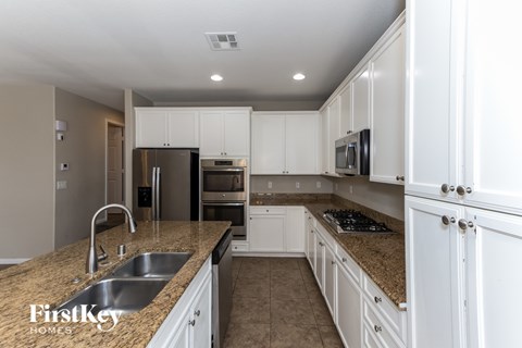 A kitchen with white cabinets and a granite countertop.