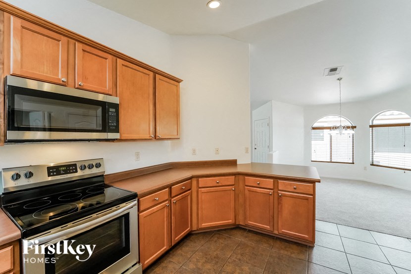 a kitchen with wooden cabinets and a stove and a microwave