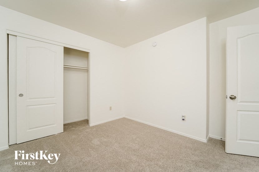 a bedroom with white walls and a closet and white doors