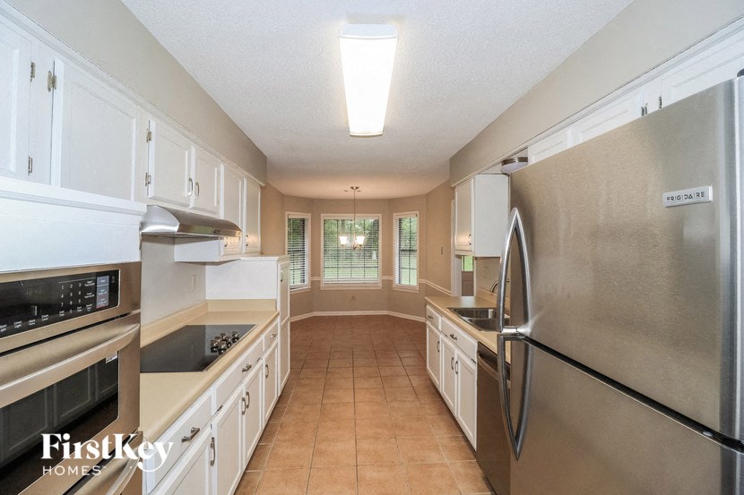a large kitchen with stainless steel appliances and white cabinets