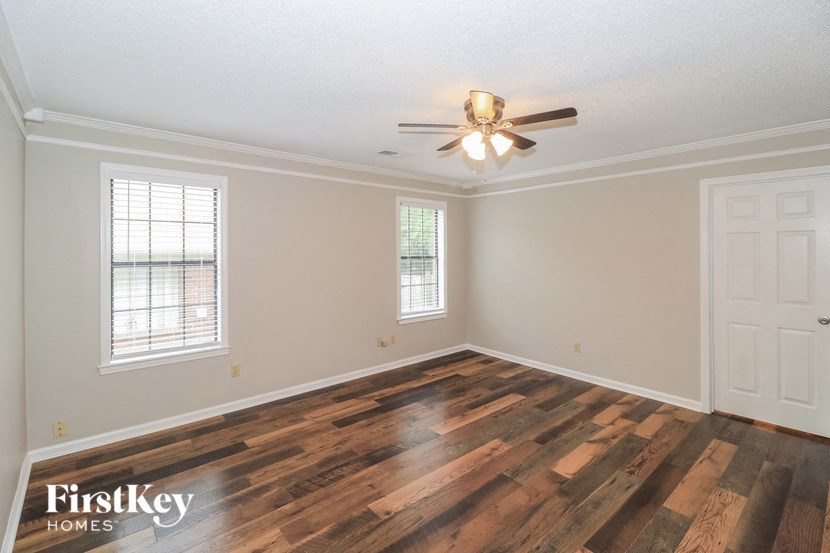 the living room of an empty house with a ceiling fan