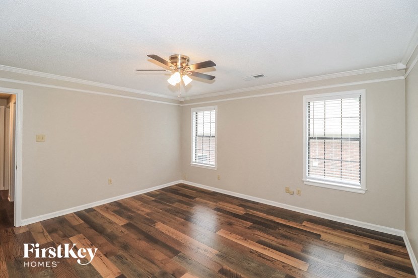 the living room of an empty house with a ceiling fan