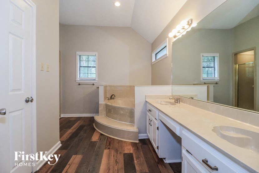 a bathroom with a tub and a sink and a mirror