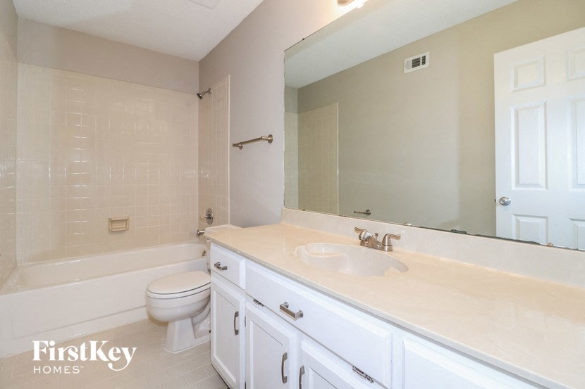 a bathroom with a sink toilet and a mirror